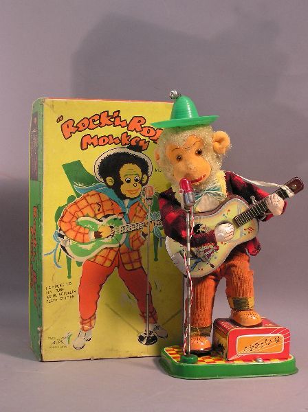 Battery Operated "Rock N Roll" Monkey: Battery operated "Rock N Roll" Monkey holding a guitar. In the original box. Not in working condition. Takes two D-cell batteries. Measures 12 inches tall.