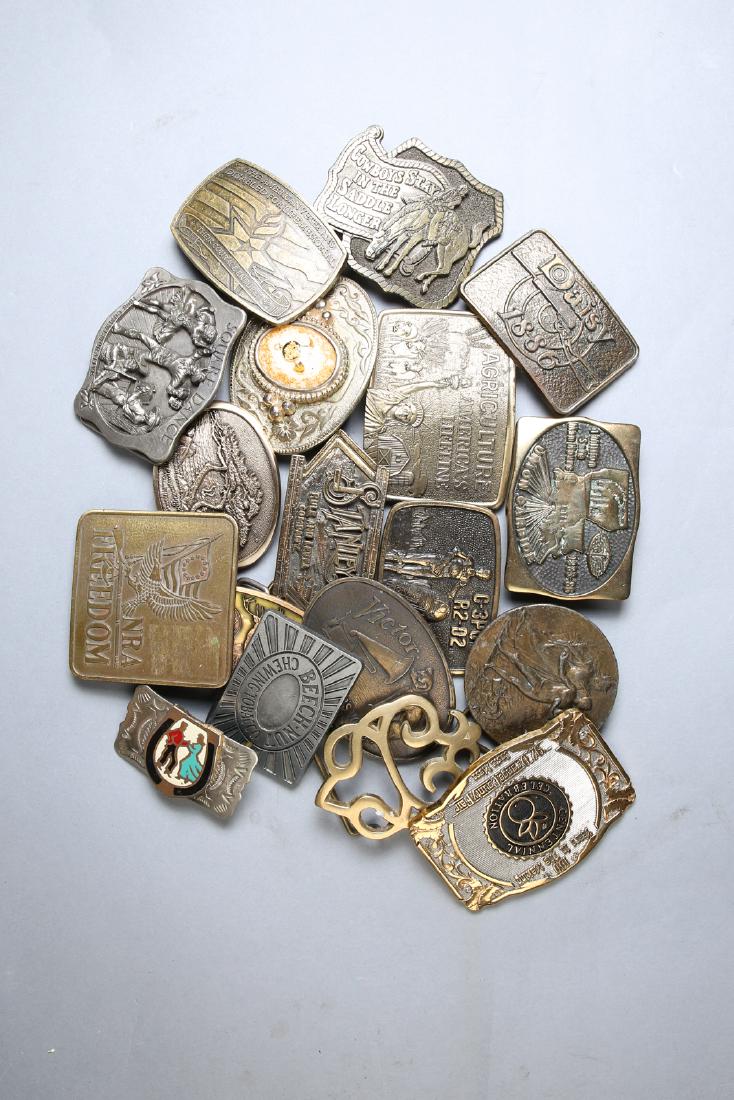 Lot of 18 Belt Buckles, Variety of Themes: Big lot of mainly brass belt buckles, mostly advertising themed from Daisy, NRA, RCA Victor and more. Included will be one Native American style in nickel silver