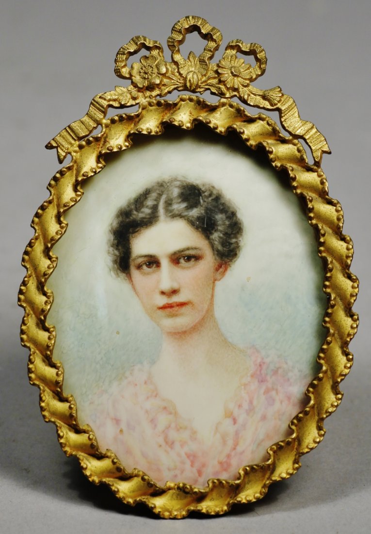 Edwardian Woman Portrait Miniature: Stunning hand painted portrait miniature of a lovely woman. She is painted on a thin sheet. This brunette lady is wearing a light pink frock and is unsigned. She comes in a brass oval frame topped wit