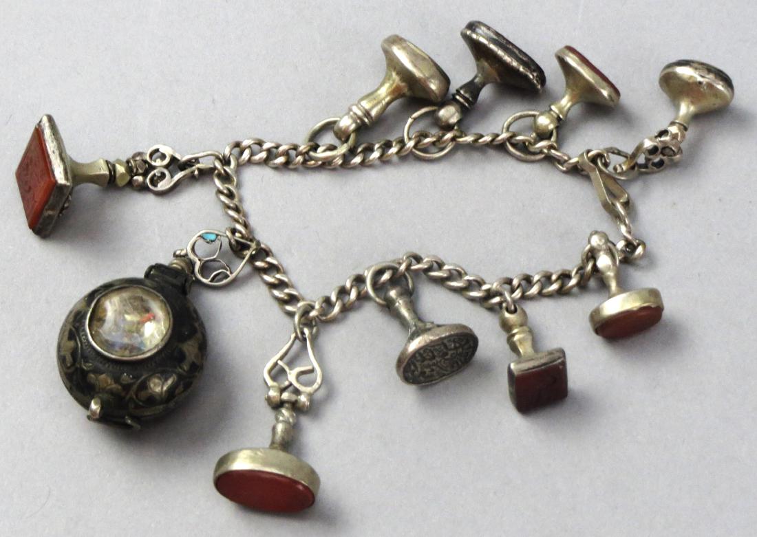 Antique Persian Sterling Wax Seal Charm Bracelet: This stunning bracelet is filled with sterling silver wax seals, all carved Persian modified arabic writing, some carved into the silver, some carved into carnelian. One charm is a bulbous locket whit