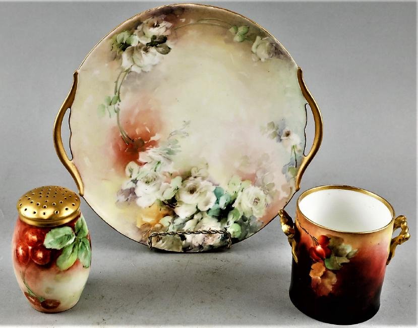 Antique Limoges T & V Porcelain Lot: Beautiful pieces in this lot that are one Tessemann & Vogt handled plate. One Delinieres & Co handled jar signed by LeRoy. and porcelain muffineer with hand painted berries and leaves.From the estate 
