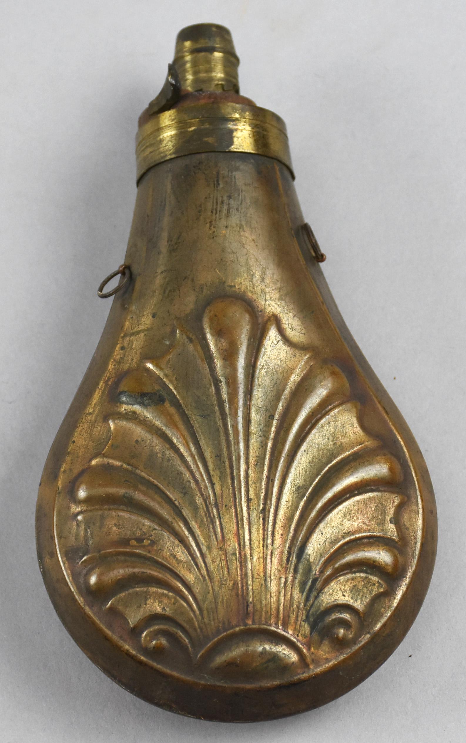 Antique Copper & Brass Powder Flask w/ Black Powder: Beautiful antique copper black powder flask filled with black powder. A stylized Fleur de Lis pattern on the body of the flask. It is about 1/3 full of black powder. Approx 6.25" long x 3.5" wide.