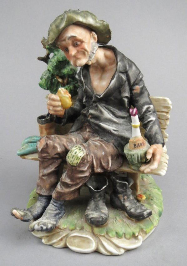 Vintage Capodimonte Porcelain Vagabond: Sweet porcelain figure of a vagabond that is attributed to Capodimonte. This old fella has a very expressive face and is sitting on a rustic bench eating a sandwich. There are two fish on his right ne