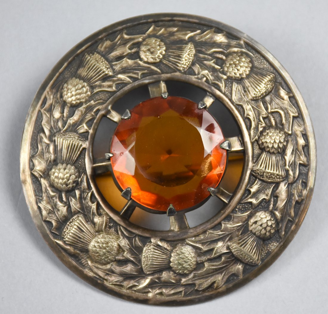 Antique Scottish Cairngorm Kilt Brooch: Antique Scottish Larger Cairngorm Kilt Brooch. With a thistle design surround the stone, and impressed "Made in Britain" on the back. Stone is in a raised mounting. 3.25 inches across on the whole pie