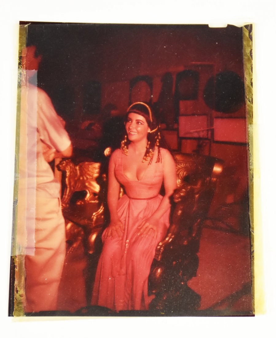Elizabeth Taylor Film Negative from Cleopatra: Here we have a beautiful young Elizabeth Taylor as her character in the hit movie, Cleopatra. Elizabeth is sitting on her gold griffin chair and talking to someone. This is an official movie negative.
