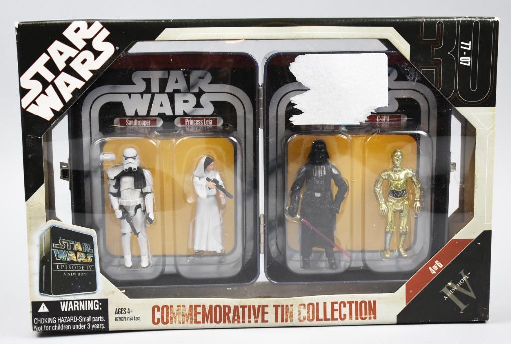 (2) Star Wars Commemorative Tins, NIB: These two 2006 Hasbro commemorative tins are for Star Wars Episode IV. They come in their original packaging and appear to have never been removed.