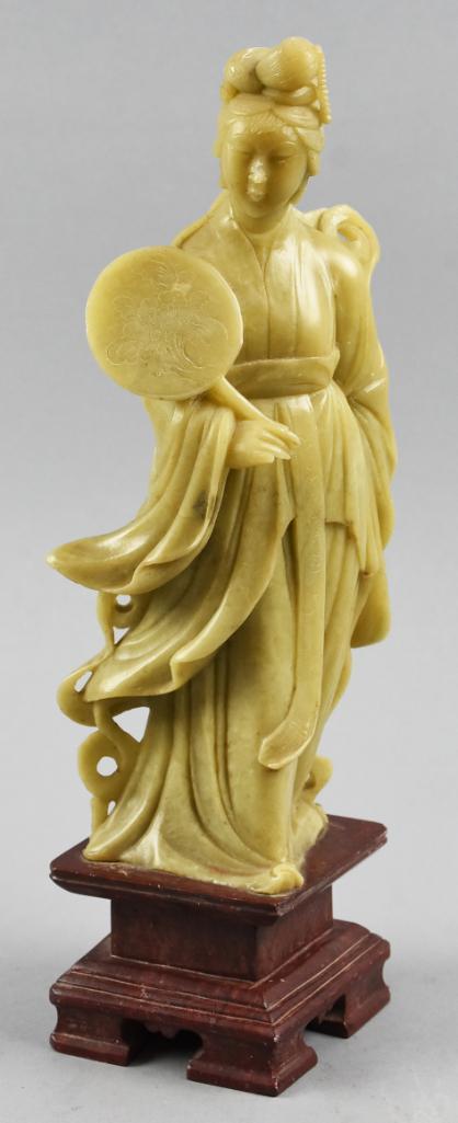 Antique Carved Soapstone GuanYin Chinese: This is a beautifully carved Guan Yin entirely in soapstone. She is holding a round fan. The base appears to be part of the same carving and is dyed in a wood color. Size is approx. 12"