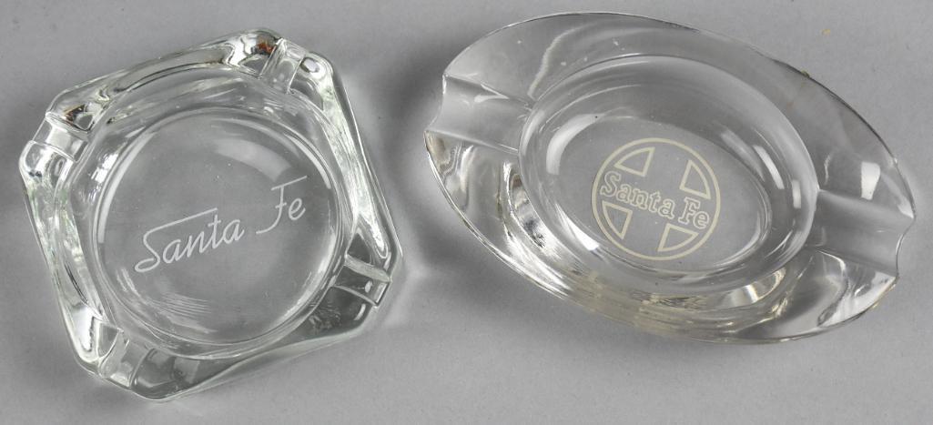 Pair Vintage Santa Fe Railway Glass Ashtrays: Nice pair of vintage ashtrays from the Santa Fe Railroad. One is nicely etched, the other has a decal. Measures 4" x 4" and 3.5" x 5.5"