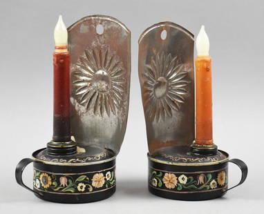 19th C Toleware Folk Art Chambersticks: This pretty pair of candlestick holders are folk art toleware. Each appears tin with embossed flower backs and hand painted flowers. Label on bottom calls them chamber sticks. Each comes with a faux c