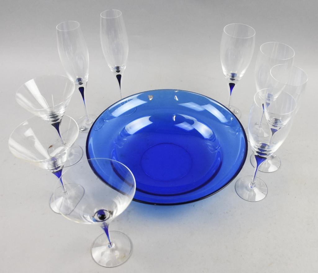 (17) Orrefors Intermezzo Blue Glass Variety w/ Bowl: Big lot of wonderful Orrefors glass in Intermezzo blue with a solid blue bowl. Pieces are and measure as follows: martini glasses - 6.5" tall wine glasses - 8.75" tall champagne flutes - 9.75" tall bo