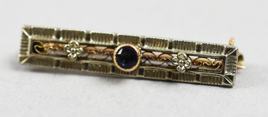 Art Deco 10K Yellow Gold & Sapphire Bar Pin: This beautiful bar pin is Art Deco in style. It is 10K yellow gold filigree and flower florets with a center set round cut sapphire. Stamped 10K on C of the C clasp. Measures approx. 1
