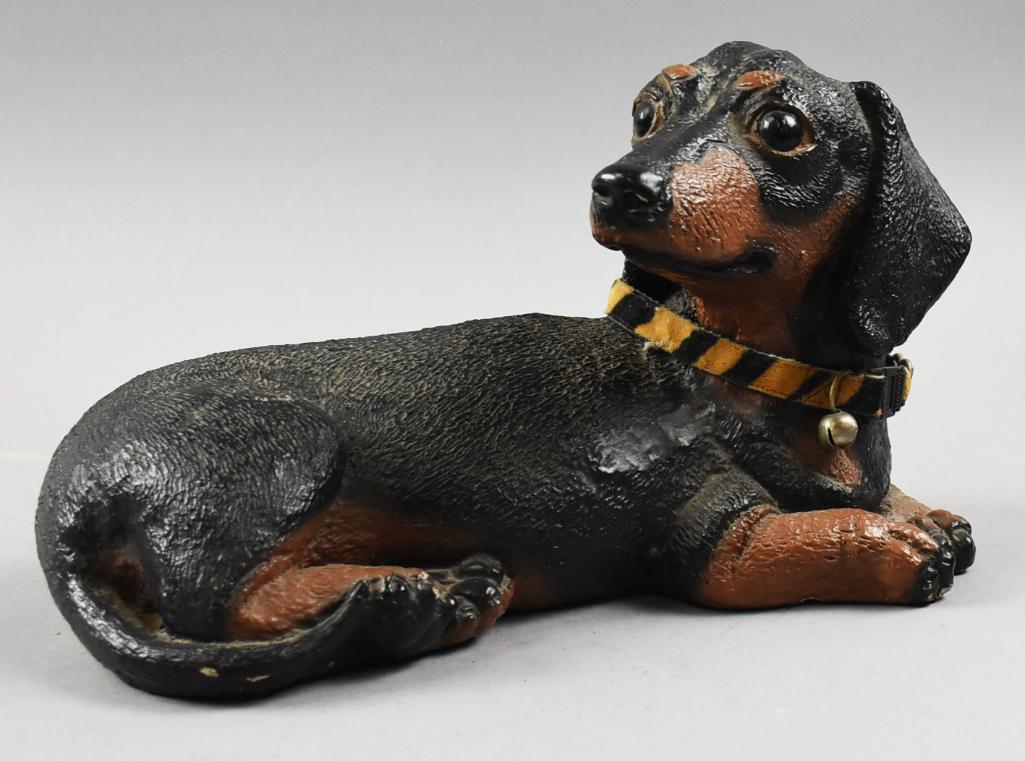 Vintage Figural Dachshund Doorstop: Sweet little Dachshund. He is laying down and looking up. Wearing a collar that appears to be added later. Measures approx 7" tall x 11" wide. Is made out of a ceramic type of material, but ve