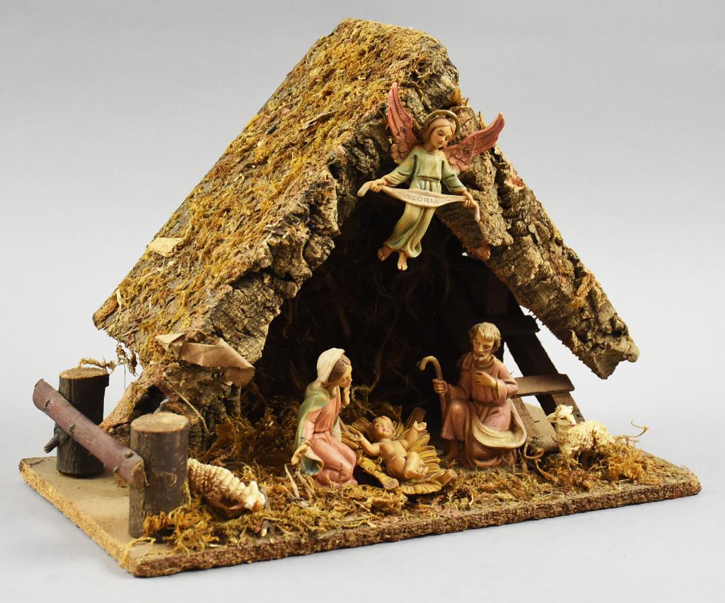 Vintage Italian Nativity Scene w/ Manger: This beautiful set is a Made in Italy Nativity scene with wooden manger accented with moss. Set is Mary, Joseph and the baby Jesus with a pair of lambs and an angel mounted to the peak. Measures appro