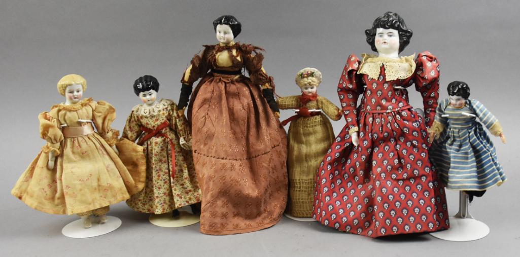 (7) Antique Porcelain & Parian China Head Dolls, 6"-11"T: Nice variety of antique china head dolls with one parian molded hat doll. One girl is stamped Germany on back, the rest are unmarked. All are wearing antique dresses, some appear original. Measure fro