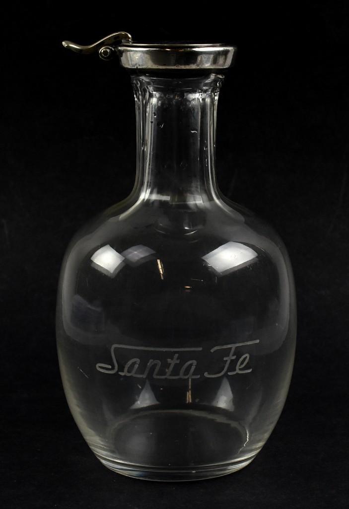 Antique Santa Fe Railway Etched Glass Carafe, Silver Plate Cover: This terrific piece of glass is an antique wine or water carafe for the Santa Fe Railway, Fred Harvey. It is etched on front in stylized lettering, the cover is impress stamped SF0683 5 and 55 in a sq