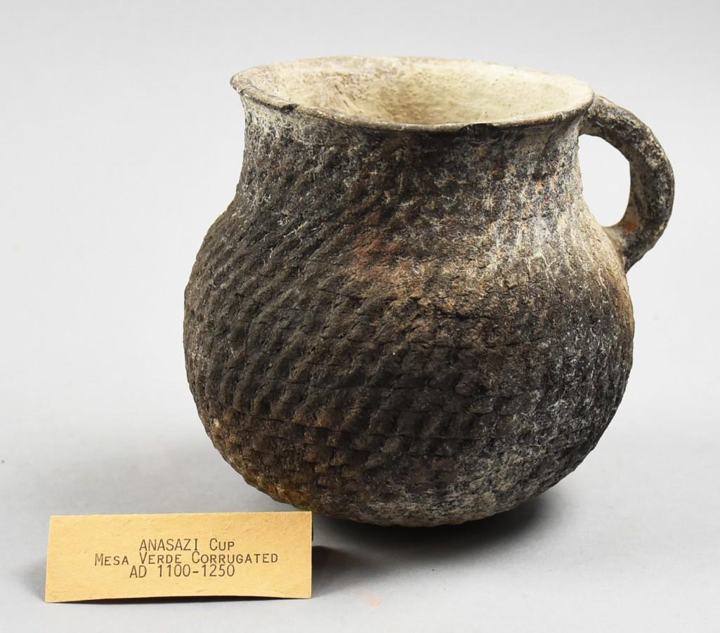 1100-1250 AD Anasazi Mesa Verde Corrugated Cup: This wonderful piece of pottery is of Anasazi culture dating from 1100-1250 AD. Mesa Verde corrugated black outer color, white inside. Stands approx 5.5" tall. NOTE: From the collection of Daniel Cutr