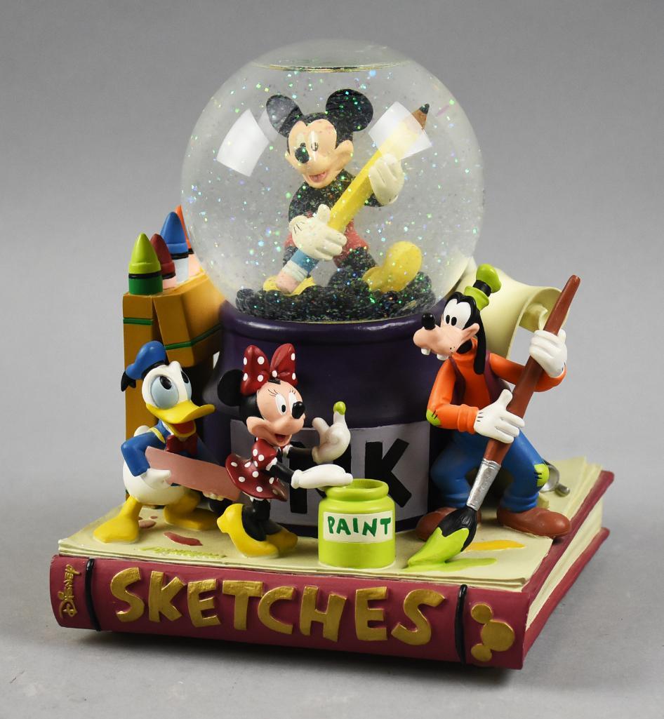 Vintage Disneyland Sketches Music Box, Snow Globe: This great music box plays Mickey Mouse Club March and is a combination snow globe. The globe sits atop an ink pot with some of the famous Disney characters creating art. 7" x 7" x 9" tall. Collecti