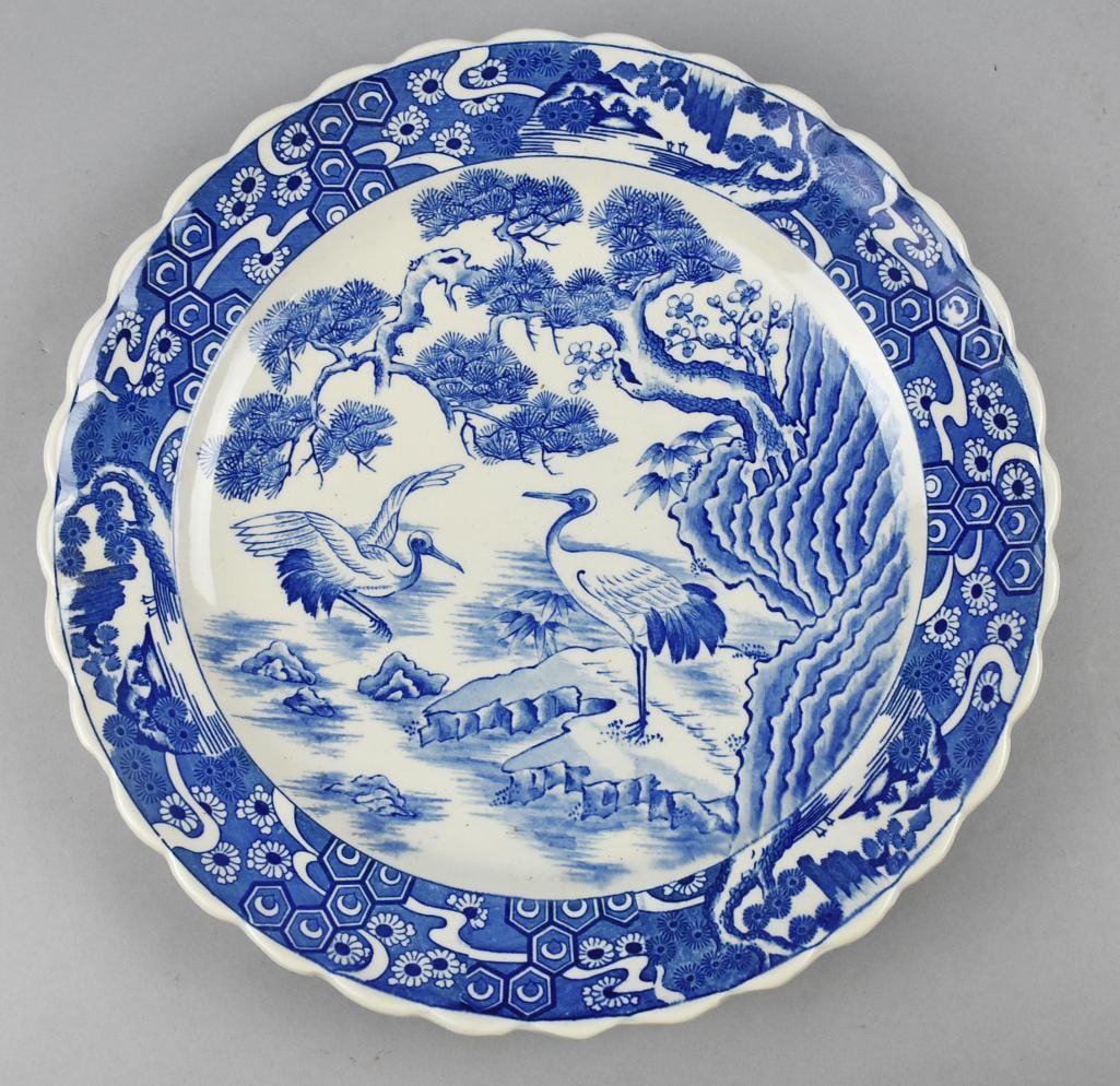 Vintage Japanese Cranes Porcelain Charger: Lovely vintage Japanese porcelain charger. Blue and white, appears hand painted with cranes in a landscape and floral scalloped rim. Retains original paper label, impressed mark on bottom may be artis