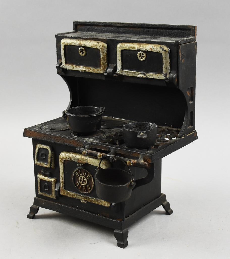 c1920 Grey Iron Cast Iron Blue Bird Salesman Sample Stove: This sweet little salesman sample and toy stove is a Blue Bird by Grey Iron. It is the medium size sample and has hand painted white accents. Comes with a miniature cast iron sauce pan and a pair of d