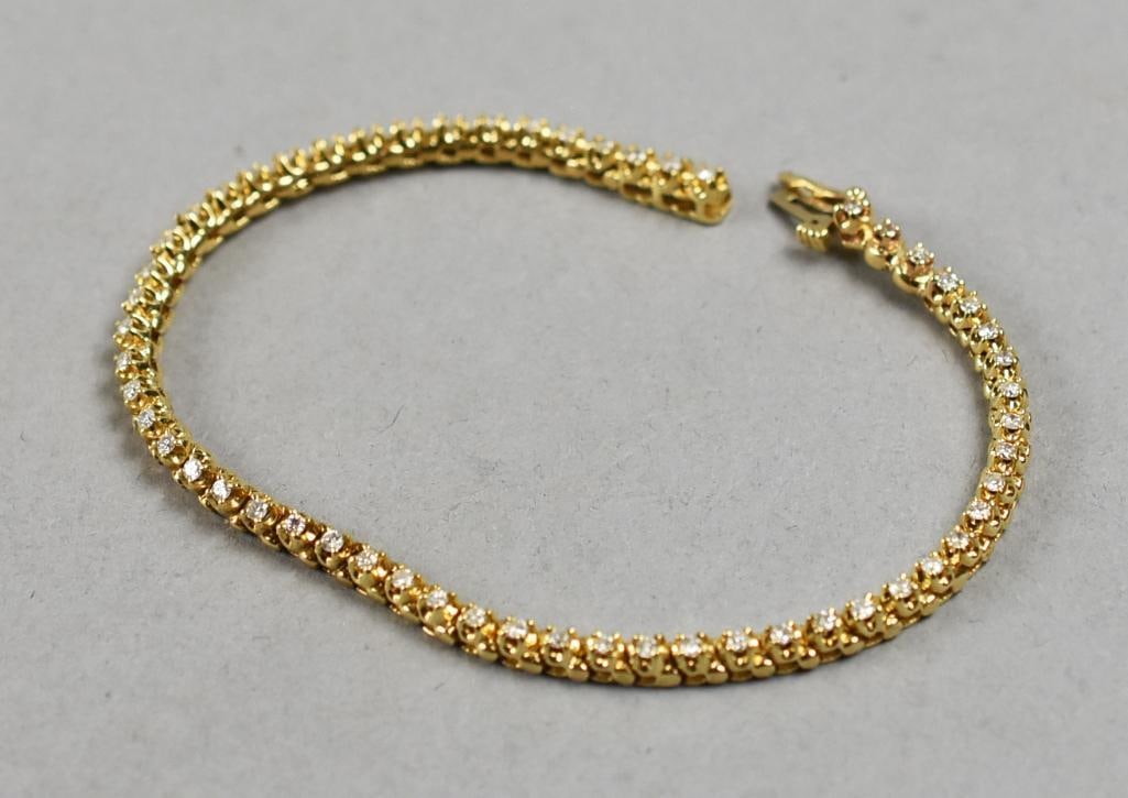 14K Yellow Gold Tennis Bracelet, 1 CTW Diamonds: Gorgeous tennis bracelet in 14K yellow gold, prong set round cut diamonds, approx 1 CTw. Stamped on locking clasp with no visible maker mark. Measures approx 7" and an overall approx weight of 10.5g. 
