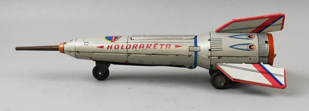 1960 Lemez Hungarian Holdraketa Tin Litho Friction Rocket: This awesome piece is vintage tin litho. It is attributed to Lemez and is a Hungarian Interkosmosz Holdraketa toy rocket. Friction toy with fold down door showing an astronaut inside. Untested, but me