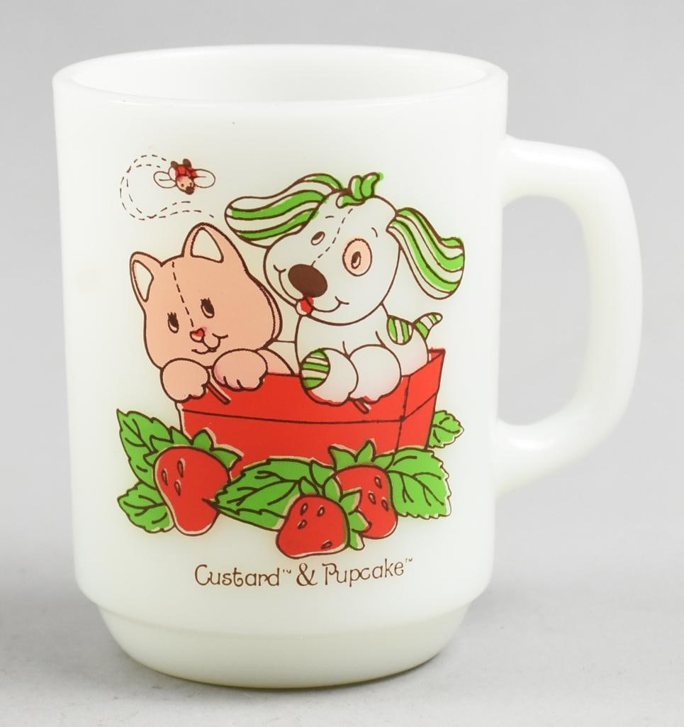 1981 Strawberry Shortcake Custard & Pupcake Mug: This is a darling American Greetings milk glass cup by Anchor Hocking. The Custard & Pupcake characters are from Strawberry Shortcake. Dated on the back below the greeting and stands approx 4" tall.