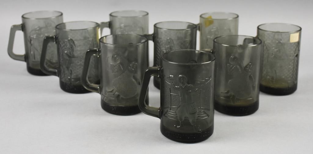 (9) c1970 McDonald's Sports Themed Smokey Glass Mugs: Lot is nine cool 1970s smokey glass mugs from McDonald's. These are all sports themed with one Ronald McDonald tossing a football, two Grimace grimace dunking a basketball and three each Captain Crook