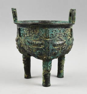 Chinese Bronze Tripod Ritual Vessel: Fantastic antique style Chinese vessel that appears bronze. Tripod ritual vessel with two handles, appears to have calligraphy around the rim, coils and other ornate details. No visible signature and
