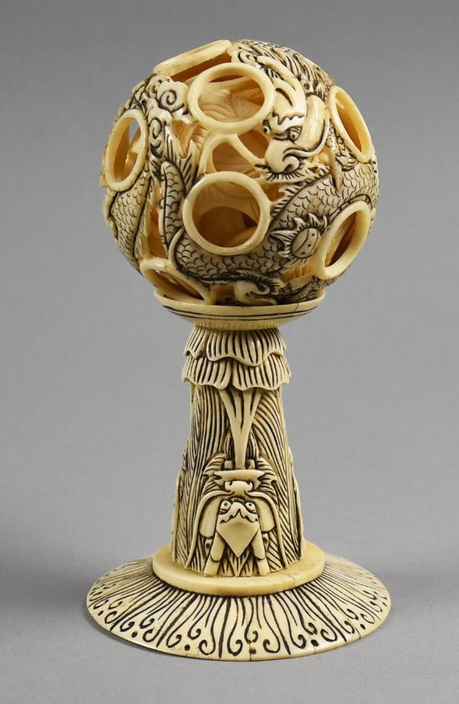 Antique Chinese Carved Bone Puzzle Ball w/ Stand: This is a stunning antique puzzle ball, Chinese export. This ball and stand appear to be bone or other natural material. Carving is done by hand with a dragon motif, highlighted by black. The stand sh