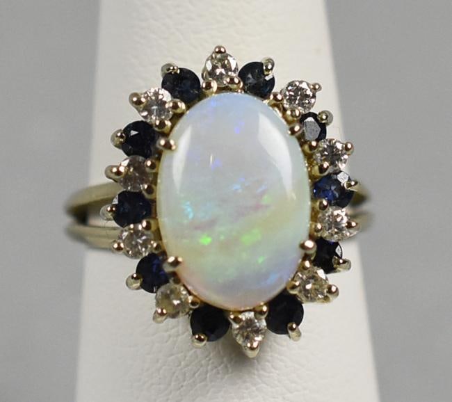 14k Gold Opal, Sapphire & Diamond Ring: Vintage 14K White Gold Opal, Sapphire & Diamond Ring Gorgeous vintage ring in 14K white gold. Ring with a oval cabochon opal totaling approx. 3.55 cttw?surrounded by alternating prong set round cut di