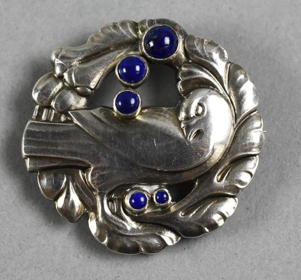 Georg Jensen Dove with Cabochon Lapis Brooch: Precious sterling silver brooch from Danish jewelry artist Georg Jensen. Dove surrounded by stylized leaves and five cabochon lapis stone accents. Well marked on back.?From the home of a collector, de