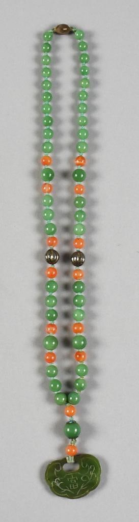 Carved Nephrite Jade & Coral Necklace: Wonderful necklace appear to be Chinese. Carved nephrite jade pendant with jade and coral beads with silver tone bead spacers. All strung on what appears to be waxed thread and knotted. Clasp stamped 