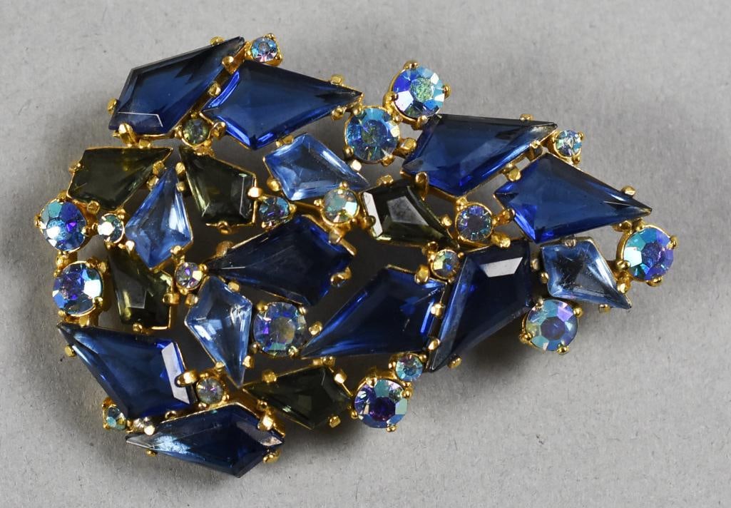 Schiaparelli Blue Crystal Rhinestone Brooch, Signed: This is a fantastic brooch from designer Elsa Schiaparelli. Mix of dark and lighter blue arrowhead shaped crystal rhinestones and round ab crystal accents. Gold plated back with designer mark on oblon