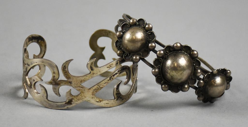 Vintage Sterling Cuff Bracelets: Gorgeous pair of sterling silver cuff bracelets. One with fine pierced scroll details and stamped inside MI925. The second appears to be Mexican sterling with stylized flowers applied to triple band.