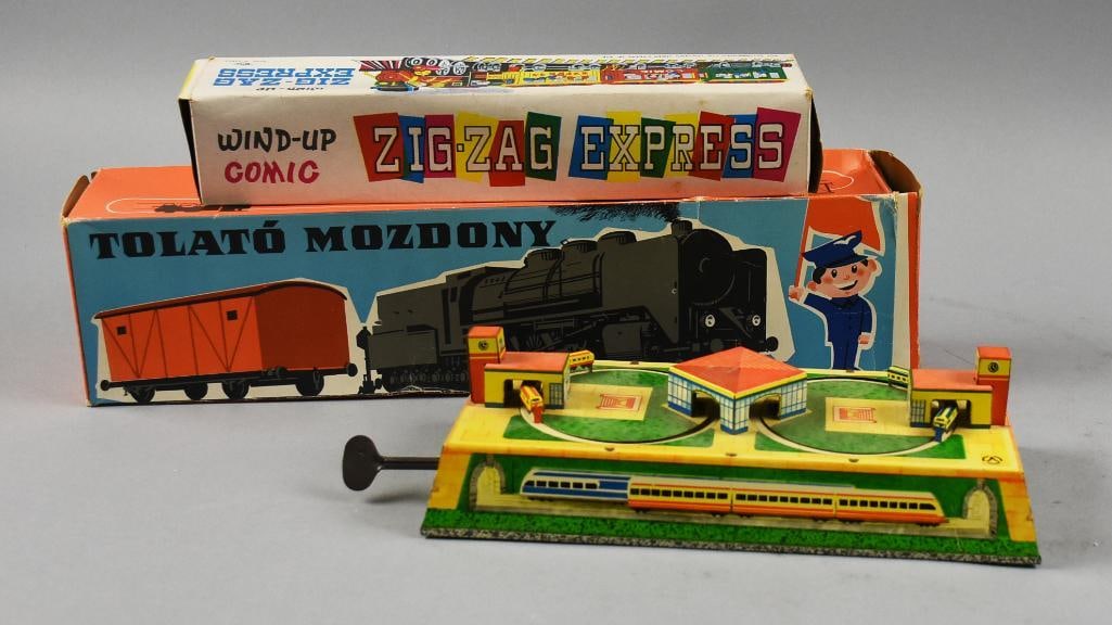 Vintage European & Asian Tin Train Wind Up Toys: This lot includes an AOPTA Russian tin train station, key wind, Hungarian Tolato?Mozdony?key wind track with train in original box and a Zig-Zag Express Wind Up Comic tin train set in original box, al