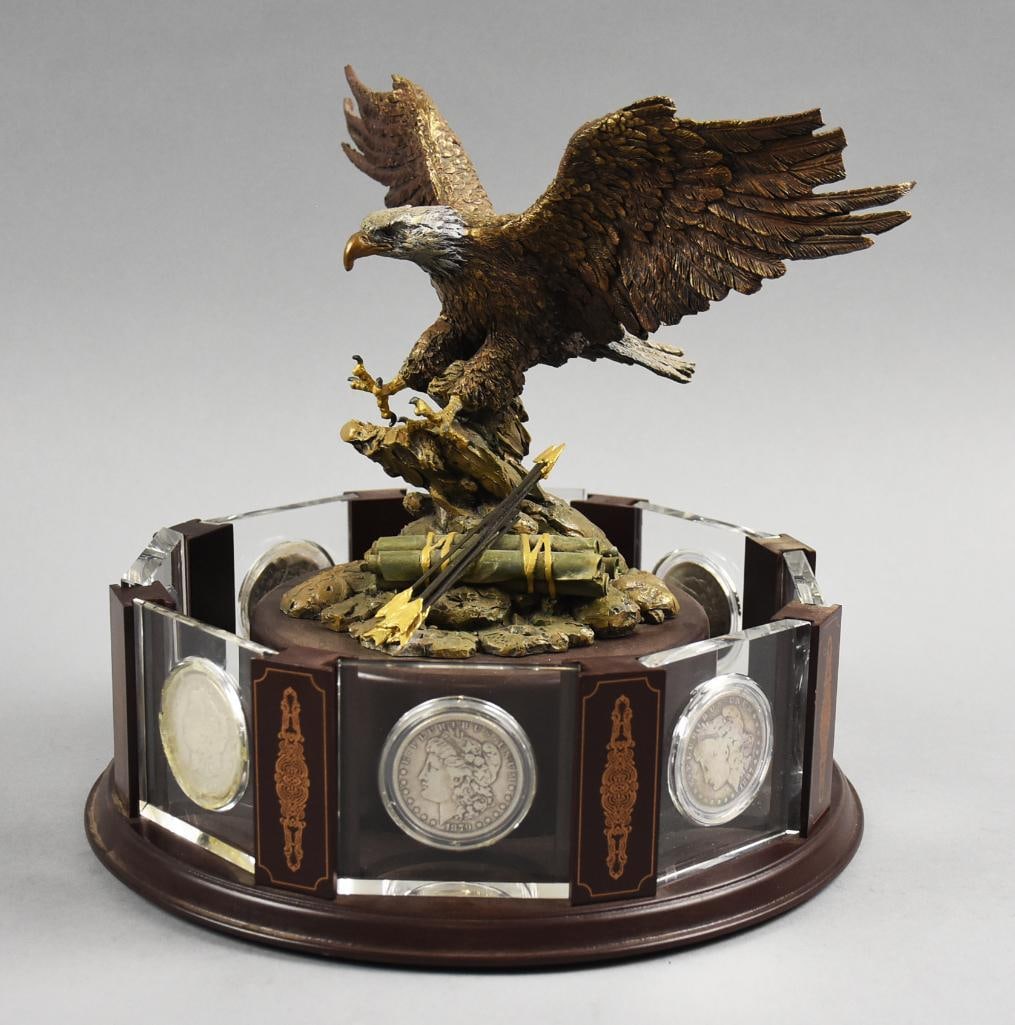 Danbury Mint Morgan Silver Dollar with Eagle Sculpture: Lot is a Danbury Mint Morgan Silver Dollar with Eagle Sculpture. The 8 coins included in this sculpture are years: 1879, 1886, 1887, 1889, 1896, 1897, 1899 and 1921. Contains 6 New Orleans Mints and 1