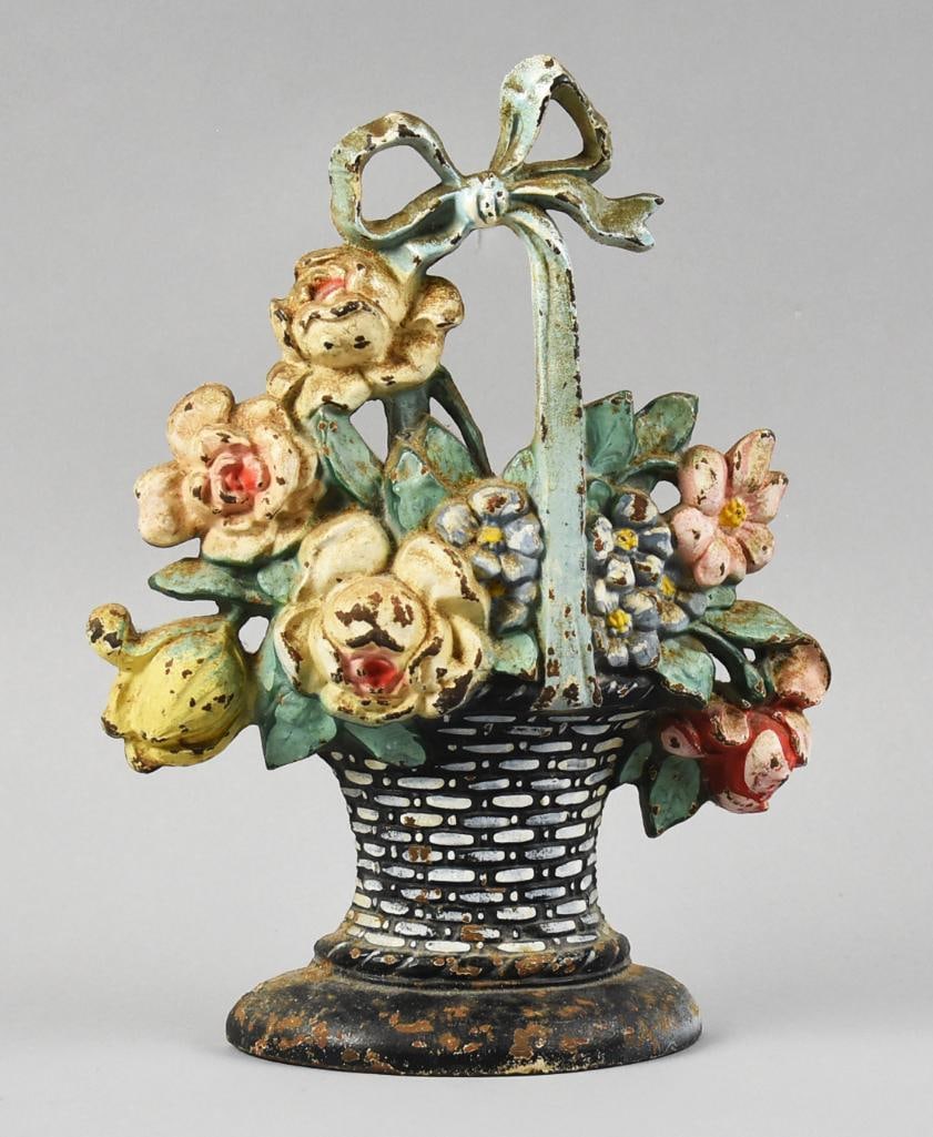 c1925 Hubley Flower Basket Cast Iron Door Stop: Gorgeous antique cast iron door stop from Hubley. In the form of a flower basket with bow, hand painted in pastel polychrome. No visible marks and measures approx. 11" x 8".?