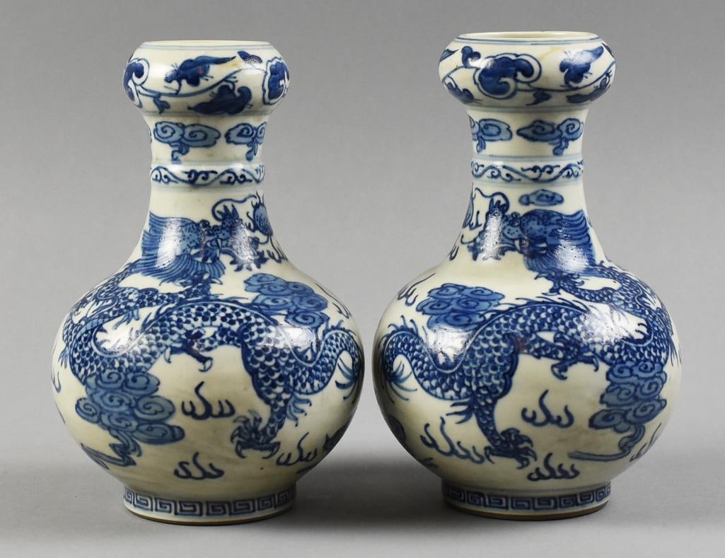 Kangxi (1662-1722) Chinese Porcelain Blue & White Vases: This pair of vases is Chinese porcelain from the Kangxi period (1662-1722). Flower and leaf detail around rim, scroll and leaf around neck. Blue dragons in clouds that wrap around the body. The base