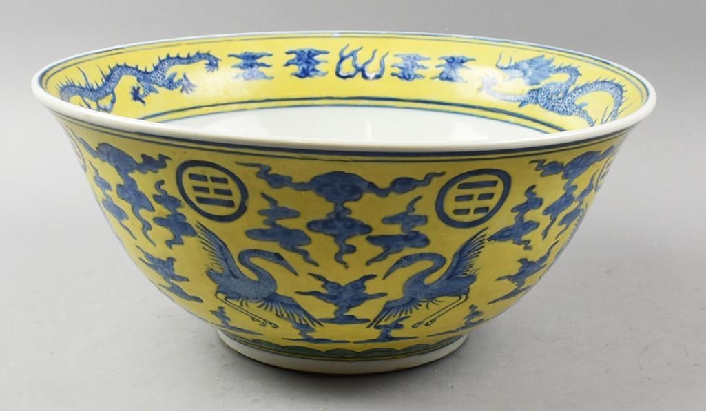 Imperial Ming Wanli Yellow Ground Dragon Bowl: This stunning and fairly large bowl is marked for Ming Wanli Period (???).? Yellow ground with blue cranes surrounded by clouds and trigrams adorn the outside.? Inner rim is dragons and flames with a