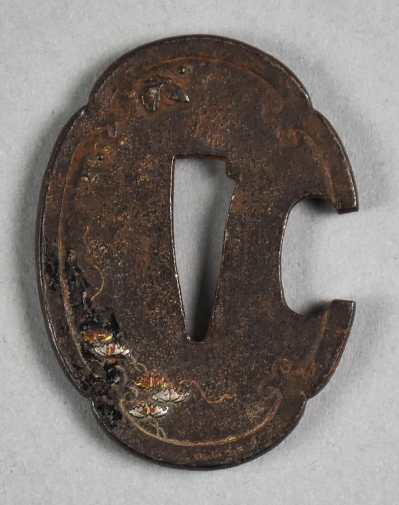 18th-19th Century Japanese Iron Tsuba, Mixed Metal: This is a wonderful Japanese tsuba. Interesting shape in iron with a touch of what appears to be both gold and silver flowers. No visible signature and measures 2" x 2.5".