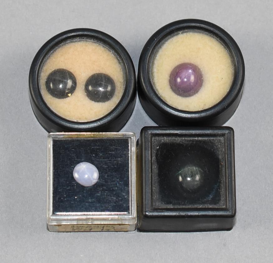 Star Gemstones, Chatoyant: Pretty assortment of various star gemstones. Includes star sapphire, star diopside, cat's eye tourmaline and what appears to be star ruby (in box marked corundum). All will come in cases as shown.