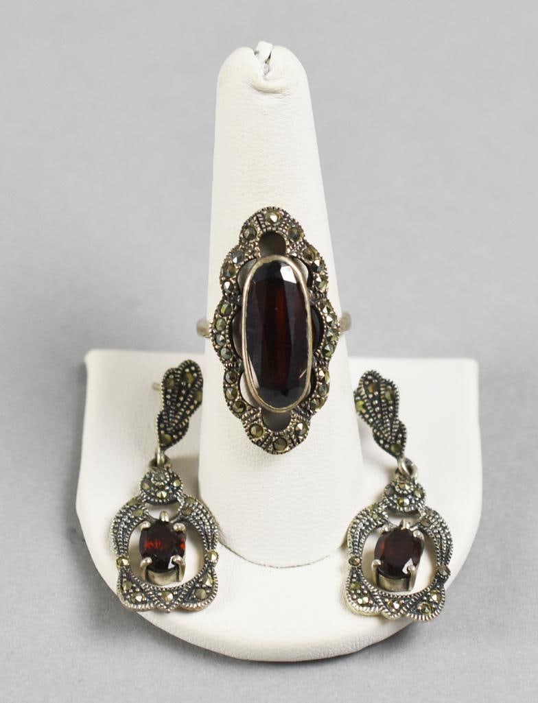 Sterling Silver, Garnet and Marcasite Earrings & Ring: Lovely set of sterling jewelry stamped MAN, unidentified designer. Lot includes a pair of pierced dangle earrings with faceted garnets and accents of marcasites. Stamped on back. Ring which does not