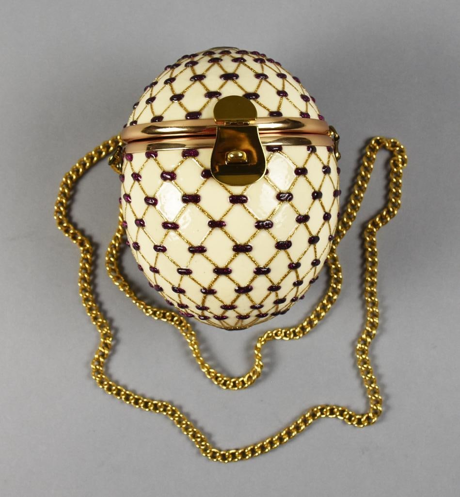 Faberge Style Evening Shoulder Bag: This beautiful evening bag is in the style of a Faberge egg. Off white enamel with purple accents and gold glittery criss cross pattern. Inside is lined with a rich purple velvet. No visible designer