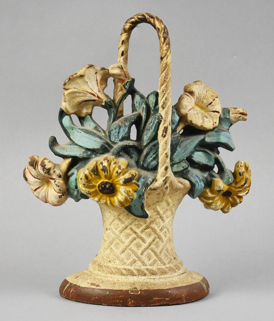c1925 Hubley Flower Basket Cast Iron Door Stop: This beautiful door stop is from Hubley. Cast iron flower basket, white and yellow flowers with green leaves, appears hand painted in polychrome. No visible marks and measures approx. 10" x 9".