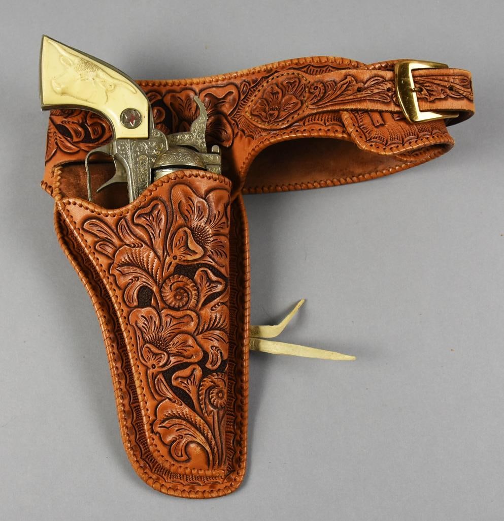 1958 Hubley Texan 38 Cap Gun, Tooled Leather Belt, Holster: Very cool vintage Hubley cap gun. It is a Texan 38 with great scroll details and a steer on the plastic grip. Comes with a genuine tooled leather belt and holster. Belt is approx. 29" long.?