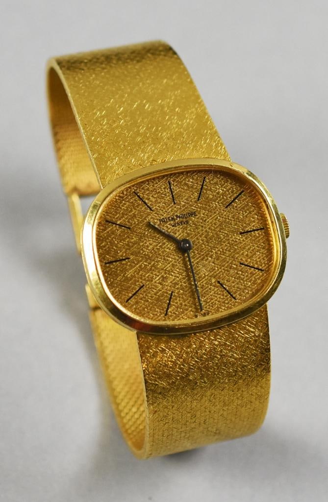 Patek Philippe 18k Golden Ellipse Watch Vintage: This fantastic watch is a vintage Patek Philippe and is in 18K yellow gold. Golden Ellipse with elliptical case and linen pattern face. Wide band is also a Patek Philippe mesh in 18K and locking clasp