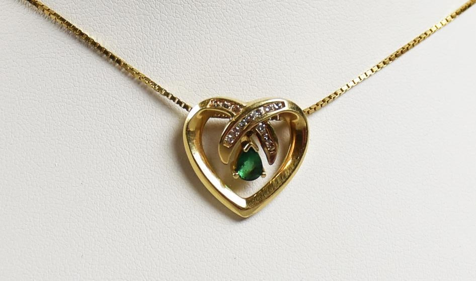 14K Yellow Gold Diamond & Emerald Heart Necklace: Lovely vintage necklace with heart pendant in 14K yellow gold. The heart has a single teardrop emerald and round cut diamond accents. It hangs from a 14K yellow gold box chain that measures approx. 19
