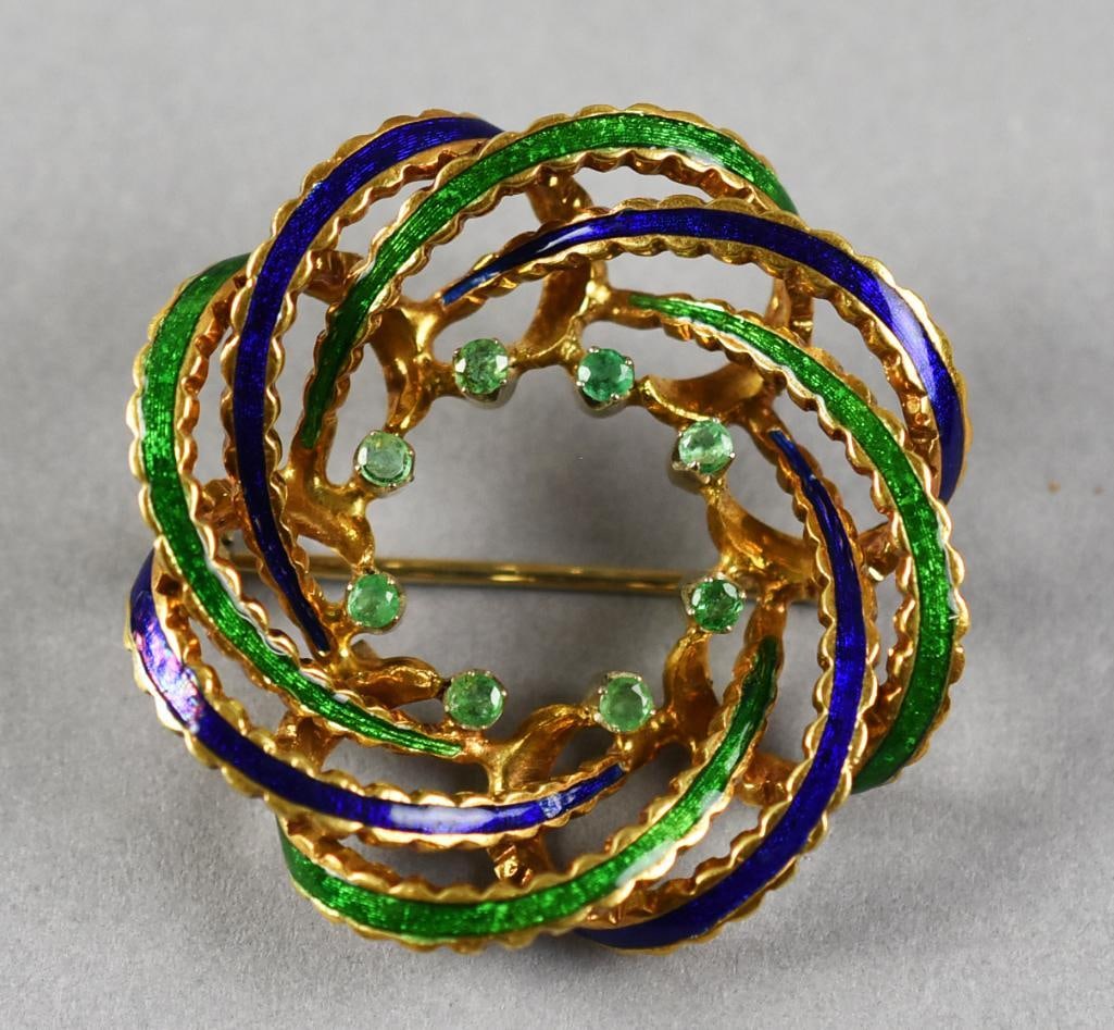 18k Emerald & Enamel Brooch: Beautiful 18k yellow gold interweaving blue and green enamel circles with approx a 1/2ct of green emeralds on the inner circle. Weight = 12.1g. Contineal European in origin.