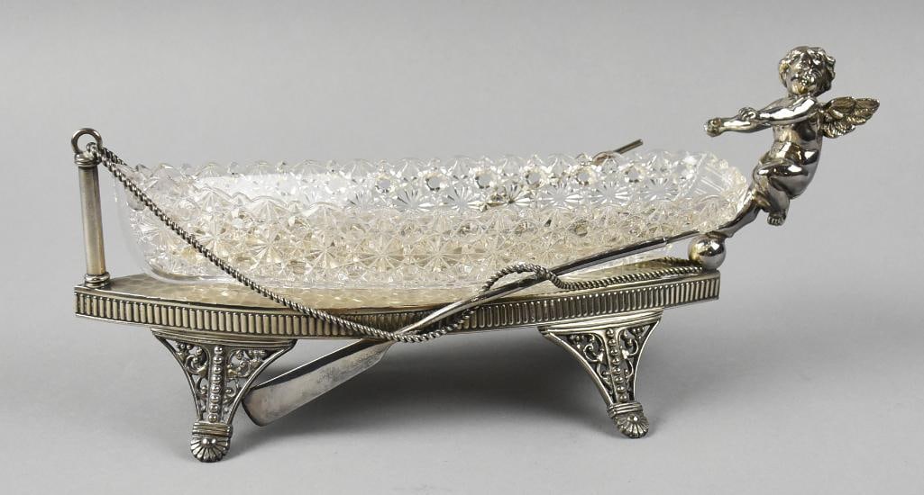 James Tufts Cherub Daisy Button Centerpiece Boat c1885: Wonderful Victorian centerpiece bowl from James Tufts Boston (1875-1891). The quadruple plate boat with a cherub reaching for the paddle, draping rope with ornate openwork feet. The clear glass boat