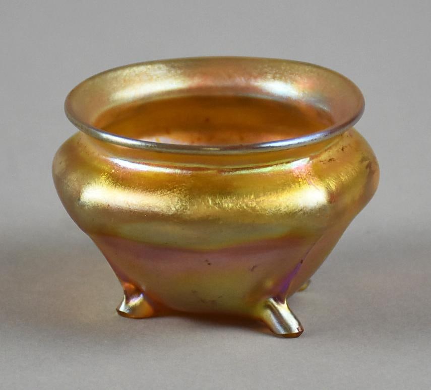 Tiffany Favrile Glass Signed Footed Salt Cellar: Spectacular antique Louis Comfort Tiffany footed salt cellar. It is favrile gold iridescent. Signed on bottom LCT. Measures approx. 1.5" x 2".